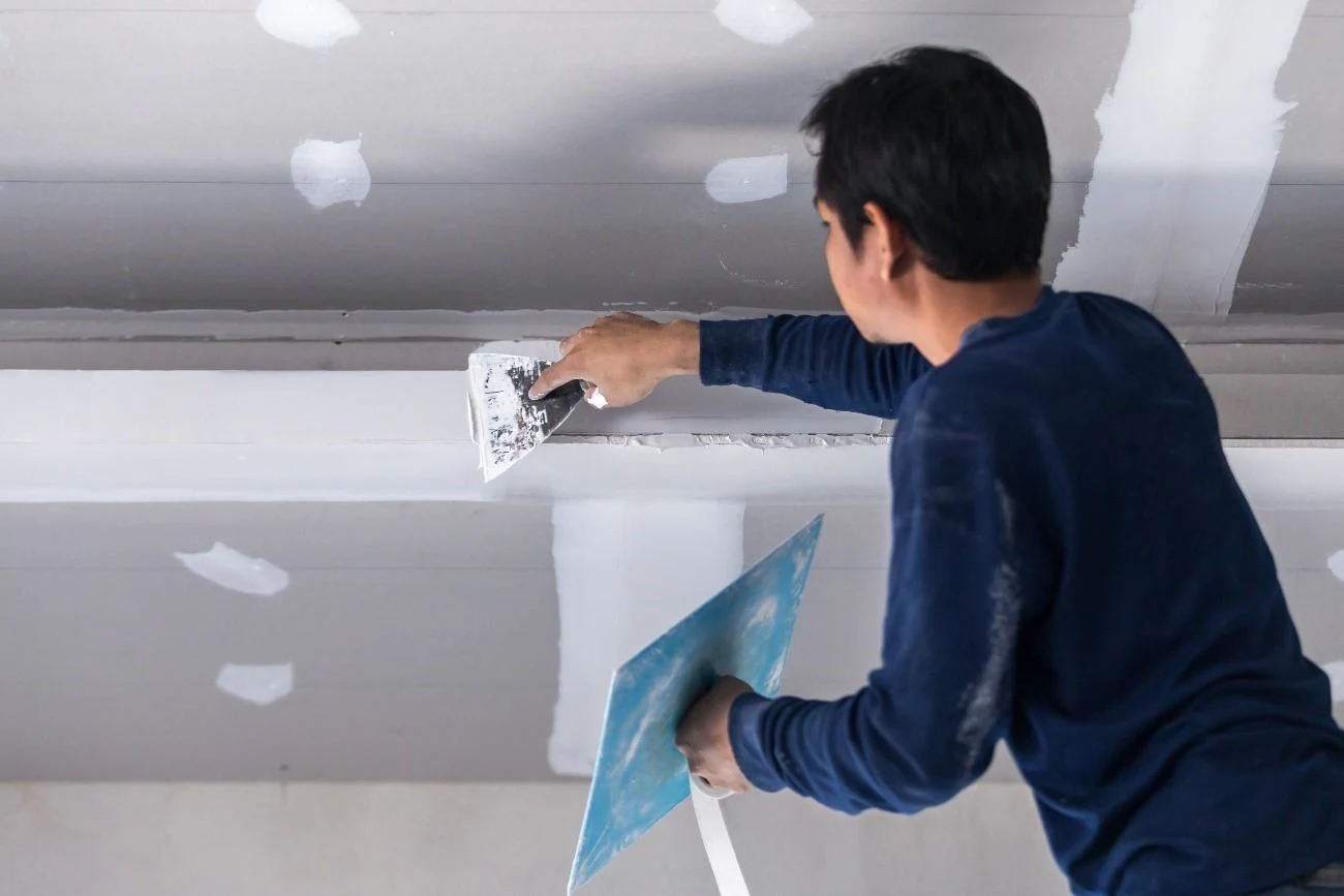 profissional-aplicando-gesso-em-Aracatuba-durante-instalacao-de-forro-de-drywall-com-acabamento-no-teto